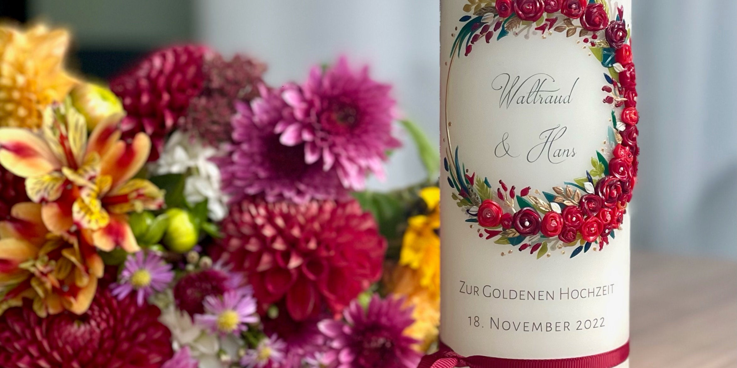 Kerze zum Ehejubiläum vor Blütenschmuck