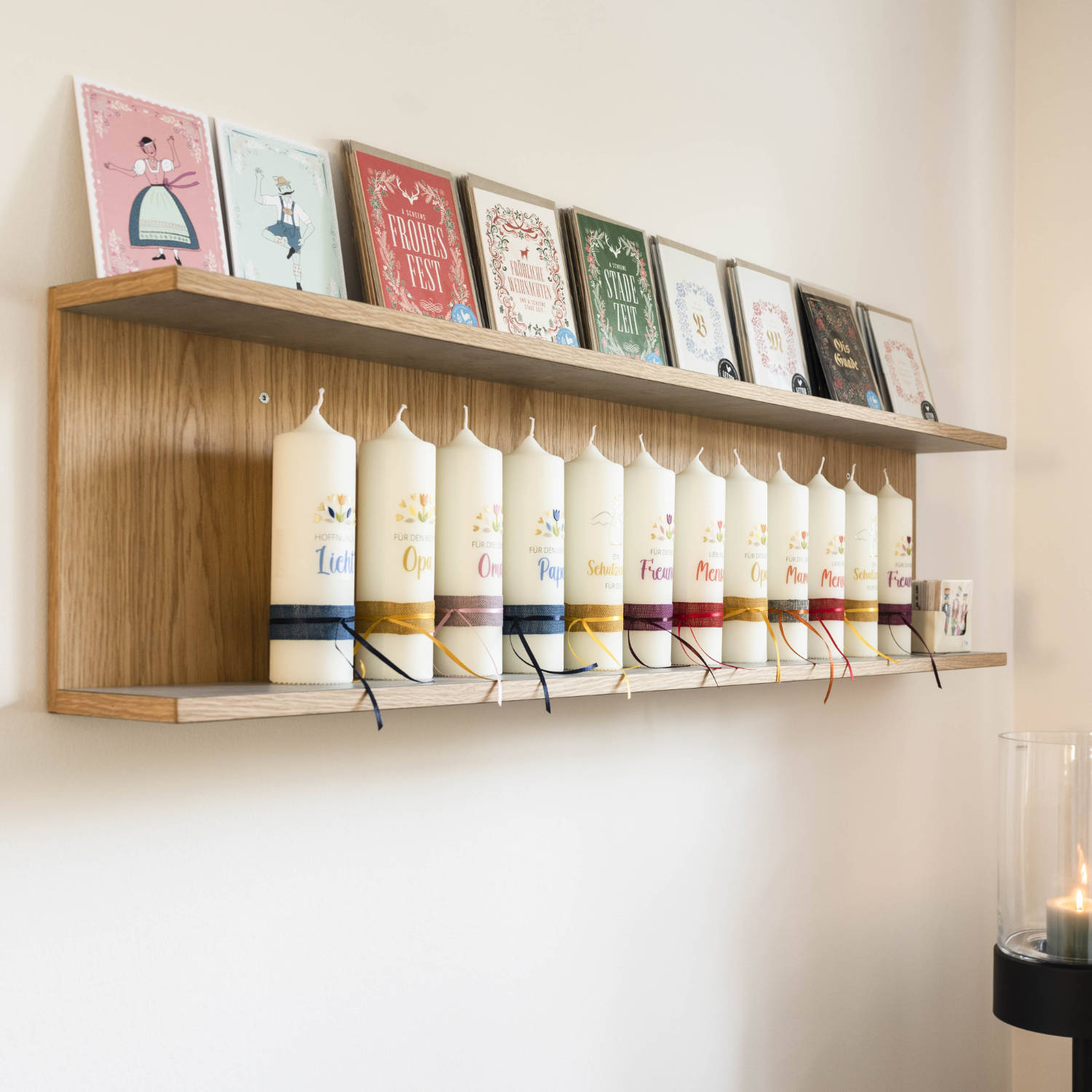 Geschenkkarten zu verschiedenen Anlässen auf einem Regal. Darunter Kerzen