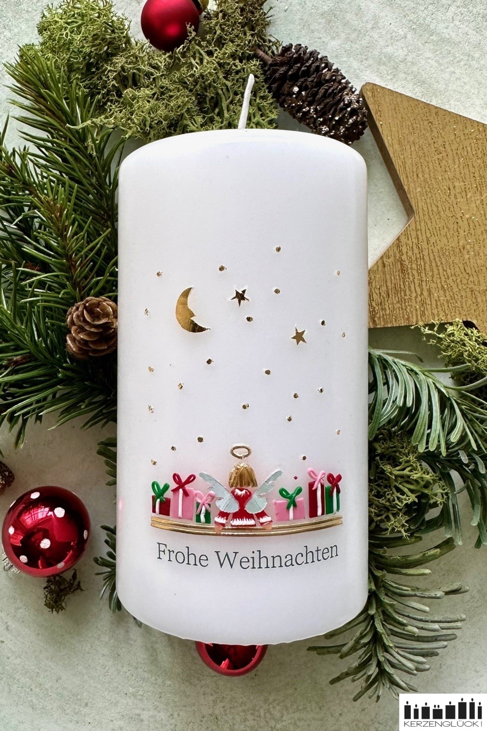 Große Weihnachtskerze mit Engel liegend auf weihnachtlicher Dekoration