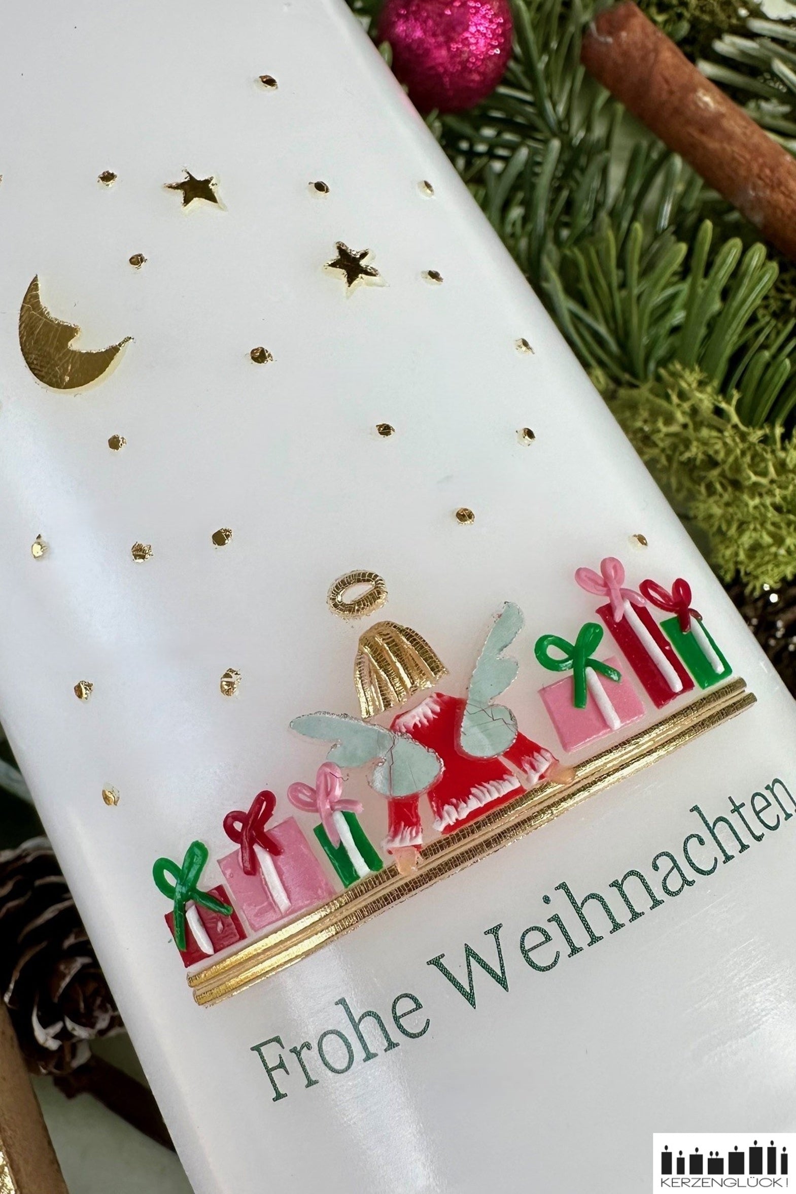 Detailaufnahme von großer Weihnachtskerze mit Engel, Wachsdekor des Engelchens, neben ihm liegen jeweils drei Pakete mit Schleifchen