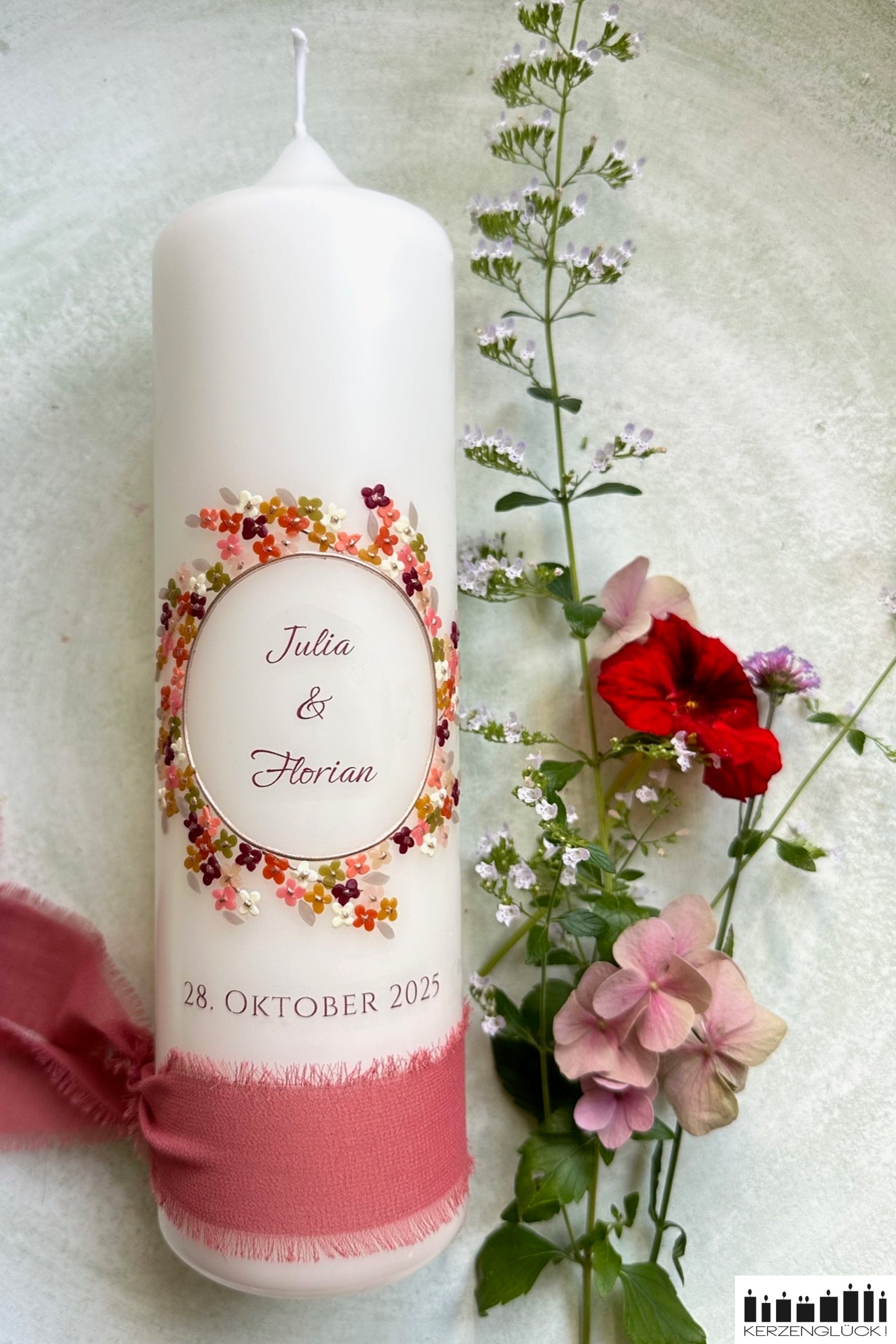 Hochzeitskerze in Herbstfarben mit bunten Blumen dekoriert