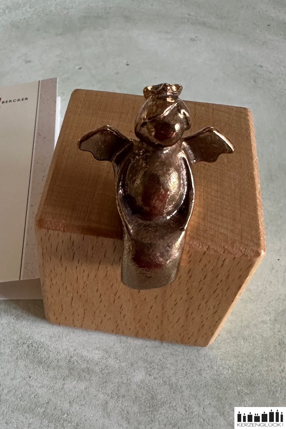 Schutzengel aus Bronze auf Holzwürfel sitzend