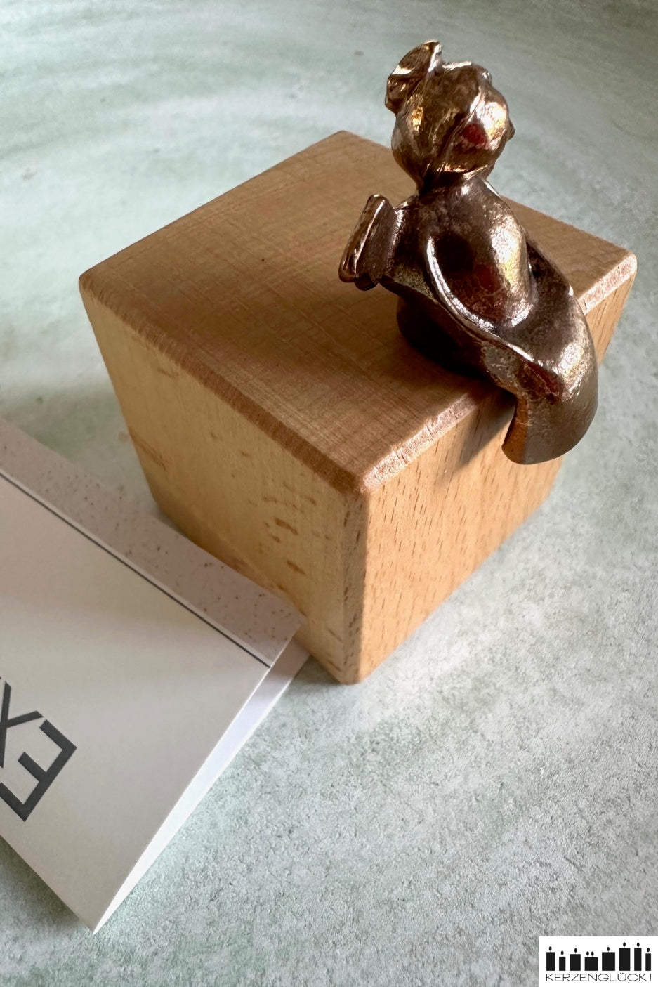 Schutzengel aus Bronze auf Holzwürfel sitzend