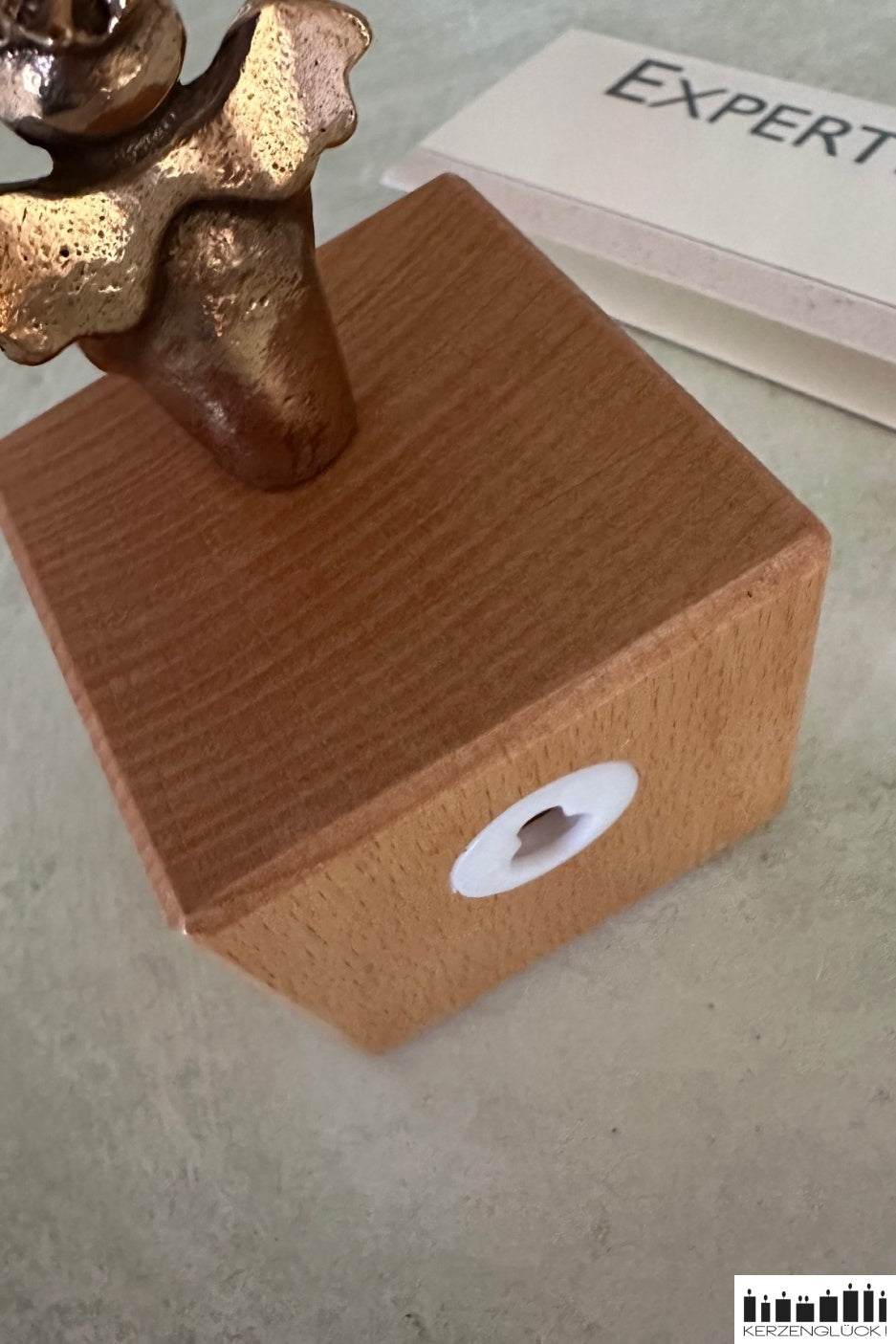 Schutzengel aus Bronze auf Holzwürfel stehend von hinten