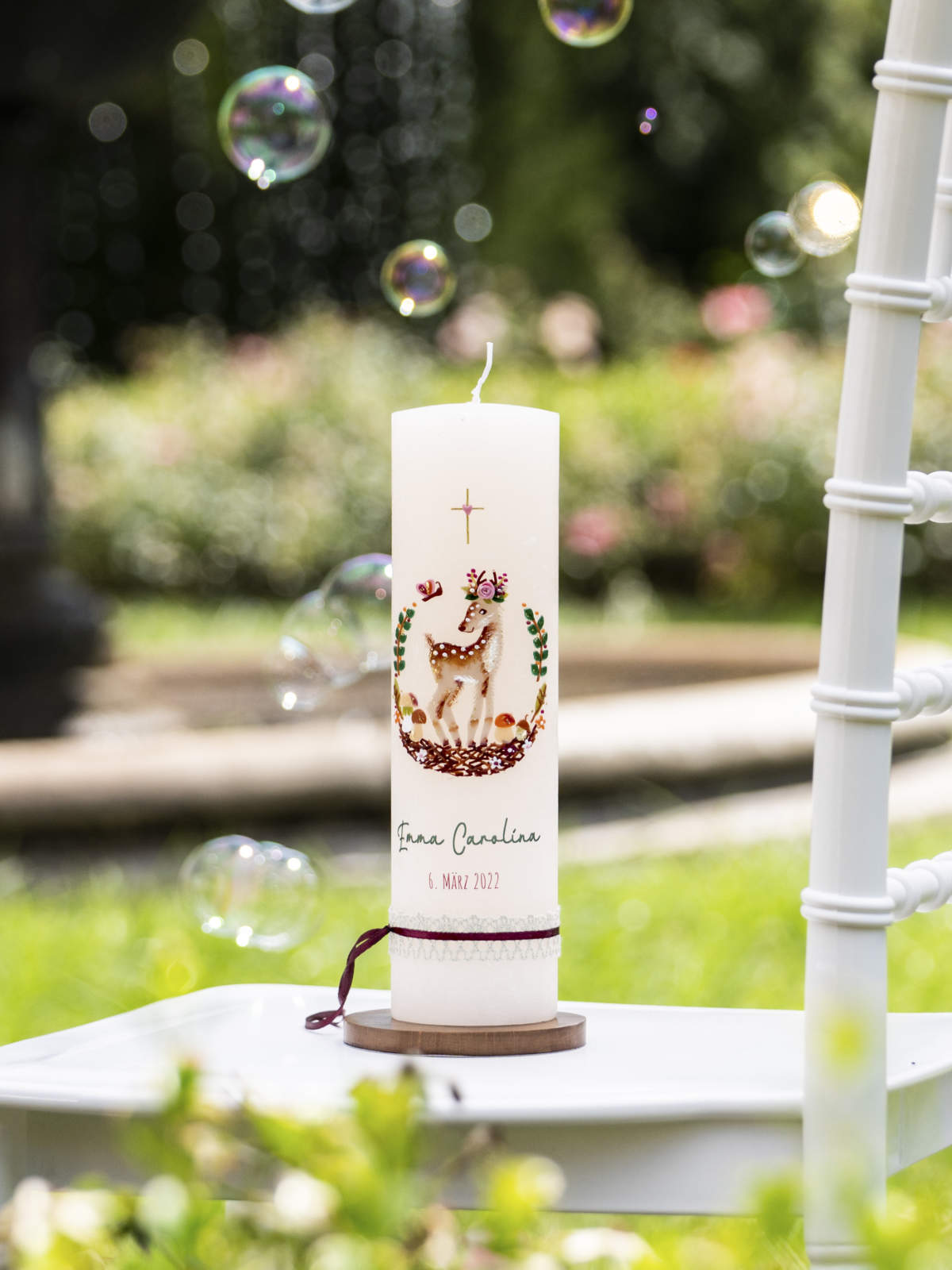 Taufkerze Reh auf einem weißen Stuhl mit Kerzenteller aus Holz