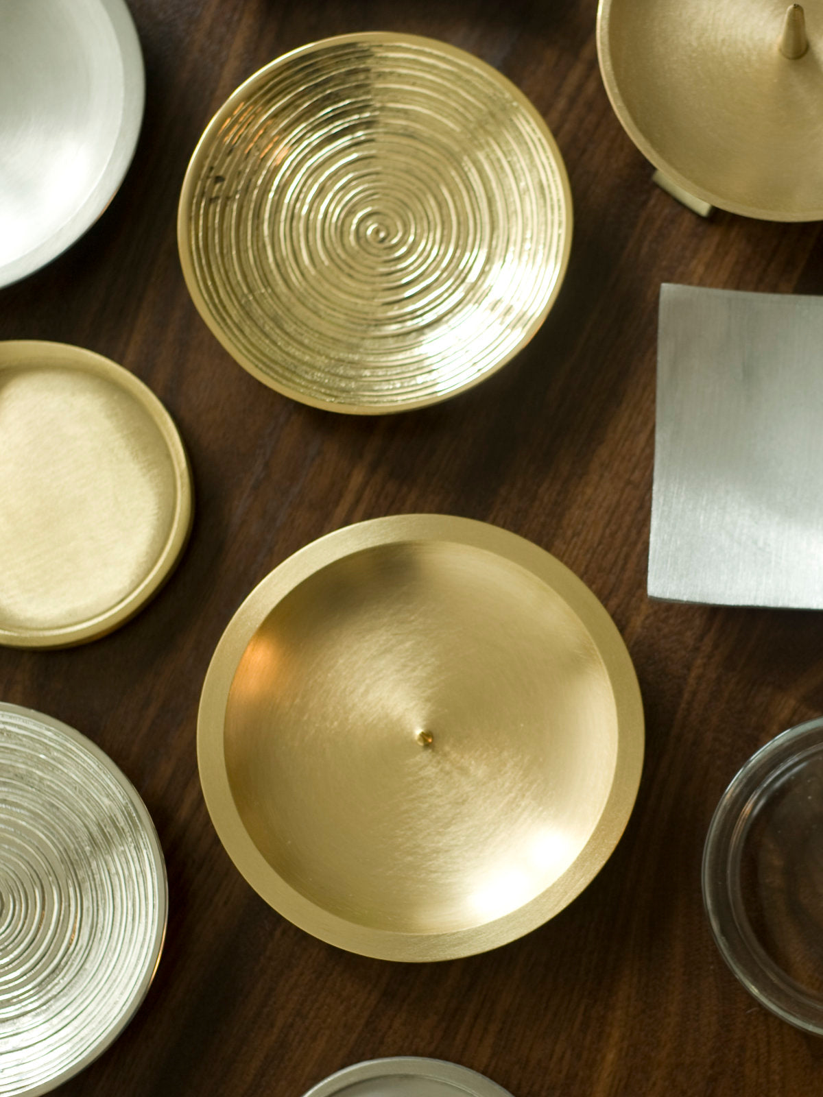 Auswahl an Kerzentellern von oben fotografiert in Gold und Silber