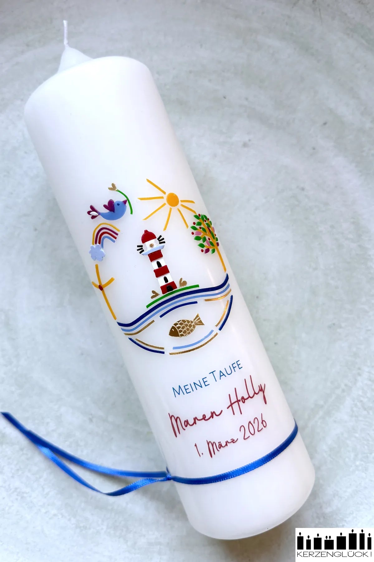 Taufkerze Leuchtturm schräg auf hellem Untergrund liegend