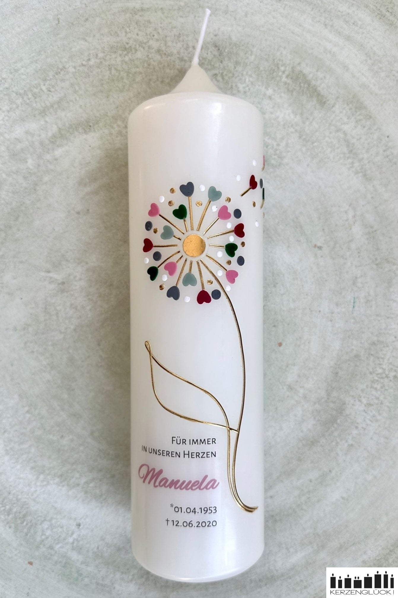 Trauerkerze Pusteblume auf einem hellen Teller liegend