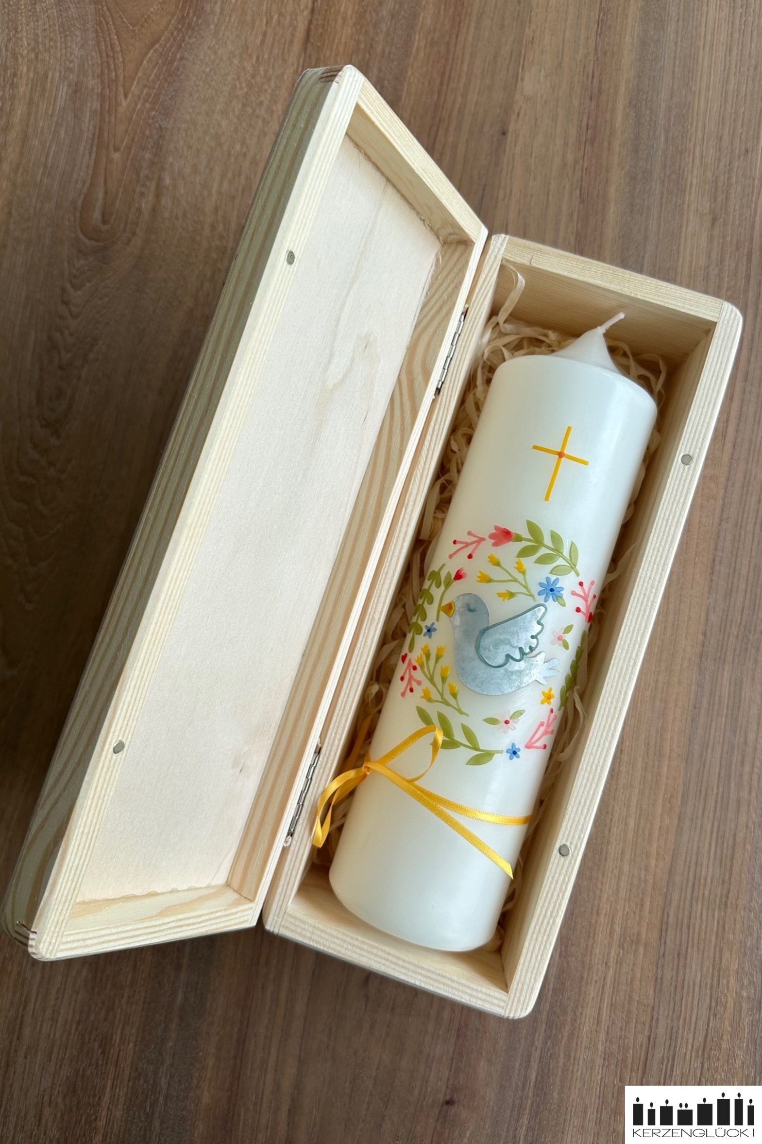 Geöffnete Holzbox mit Kerze auf Holzwolle liegend