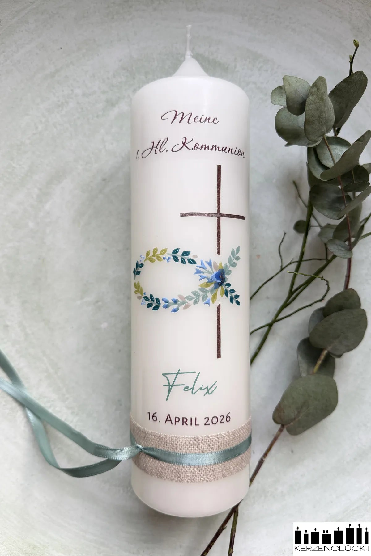 Kommunionkerze Fisch mit Kreuz auf hellem Untergrund liegend